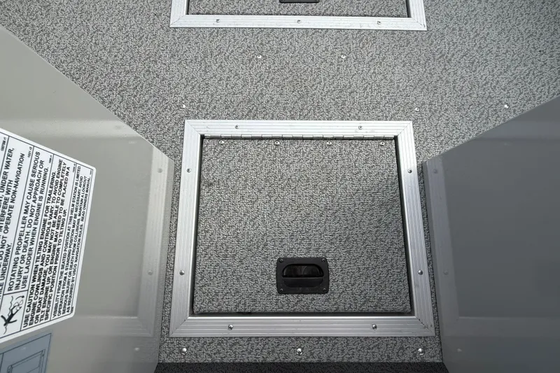 Slide: The Image of 2025 Smoker Craft Osprey 162 boat interior with storage compartment and safety label. - 24