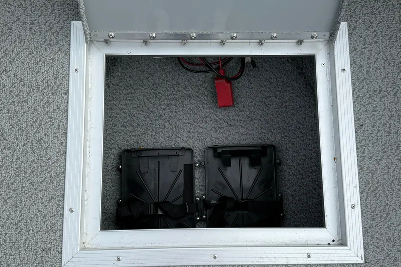 Slide: The Image of 2025 Smoker Craft Osprey 162 boat battery compartment with dual battery holders. - 26
