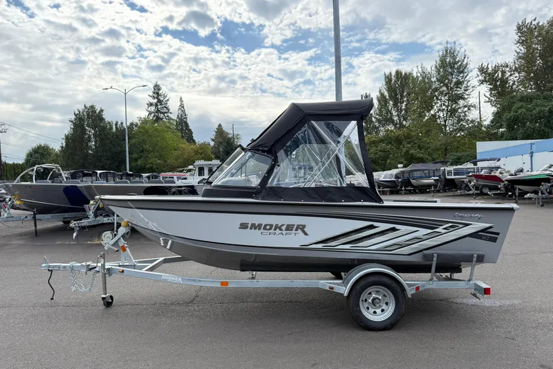Slide: The Image of 2025 Smoker Craft Osprey 162 boat on trailer, parked outdoors under cloudy sky. - 27