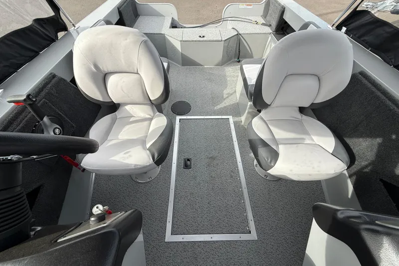 Slide: The Image of 2025 Smoker Craft Osprey 162 interior with two cushioned seats and steering console. - 8
