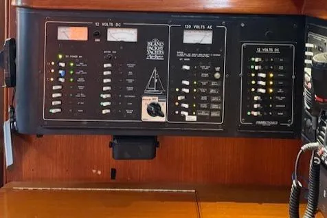 Slide: The Image of Control panel of a 1995 Island Packet 37 sailboat, featuring various switches and gauges. - 10