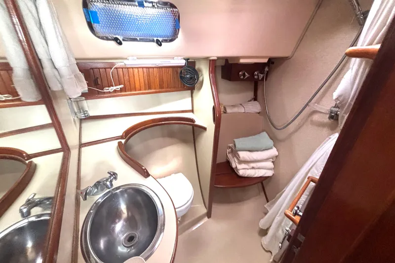 Slide: The Image of 1995 Island Packet 37 yacht bathroom with sink, shower, and wooden accents. - 13
