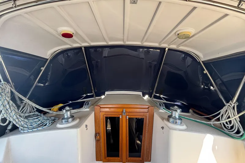 Slide: The Image of 1995 Island Packet 37 sailboat cockpit with ropes and wooden hatch. - 15