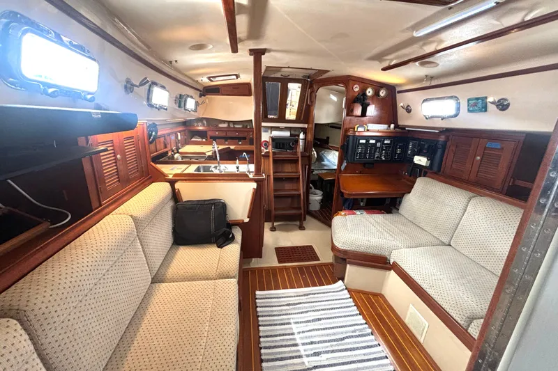 Slide: The Image of Interior of a 1995 Island Packet 37 sailboat with cozy seating and wooden finishes. - 7