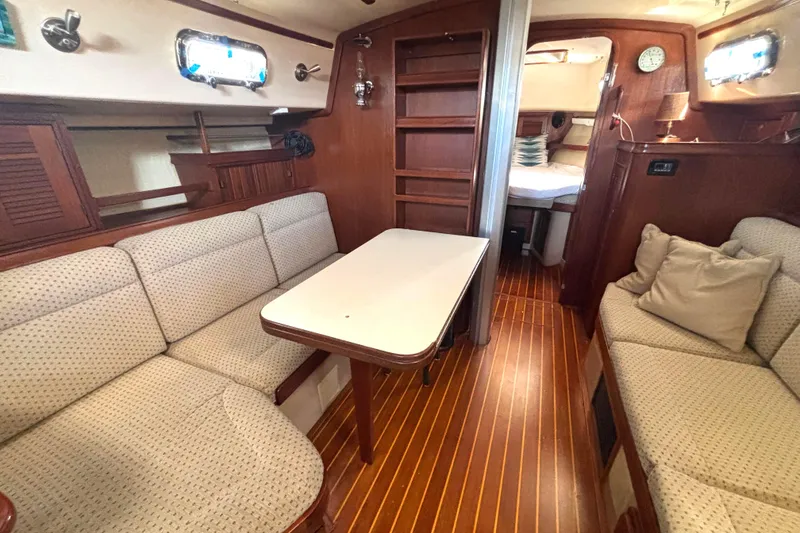 Slide: The Image of Interior of 1995 Island Packet 37 sailboat with cozy seating and wooden finishes. - 8