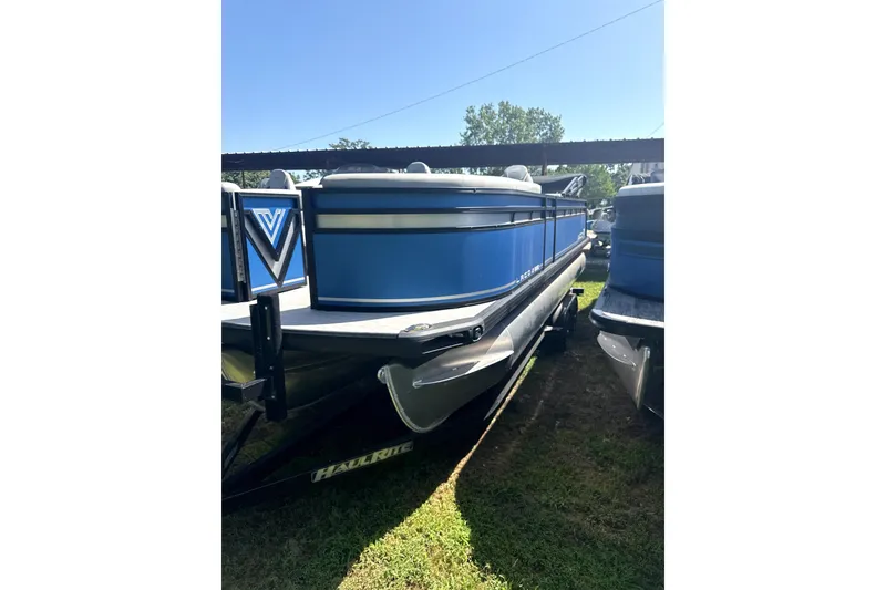 The Image of 2024 Viaggio Lago X-S pontoon boat in blue, parked on grass under sunlight. - 0