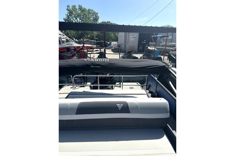 Slide: The Image of 2024 Viaggio Lago X-S boat with covered seating, docked outdoors. - 5