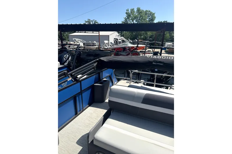 Slide: The Image of 2024 Viaggio Lago X-S boat interior with seating and canopy, parked outdoors. - 9