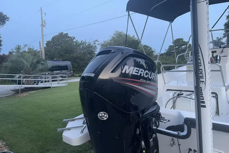 Slide: The Image of 2015 Boston Whaler 170 Montauk with Mercury outboard motor in a grassy yard. - 12