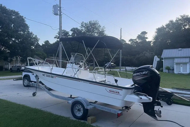 Slide: The Image of 2015 Boston Whaler 170 Montauk boat on trailer with Mercury engine in driveway. - 3
