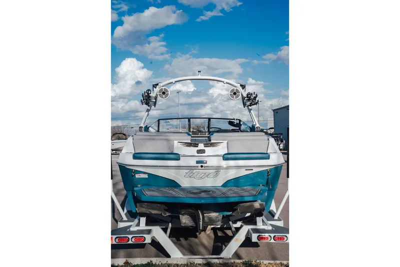 Slide: The Image of 2022 Tigé Z1 boat on trailer under blue sky with clouds. - 2