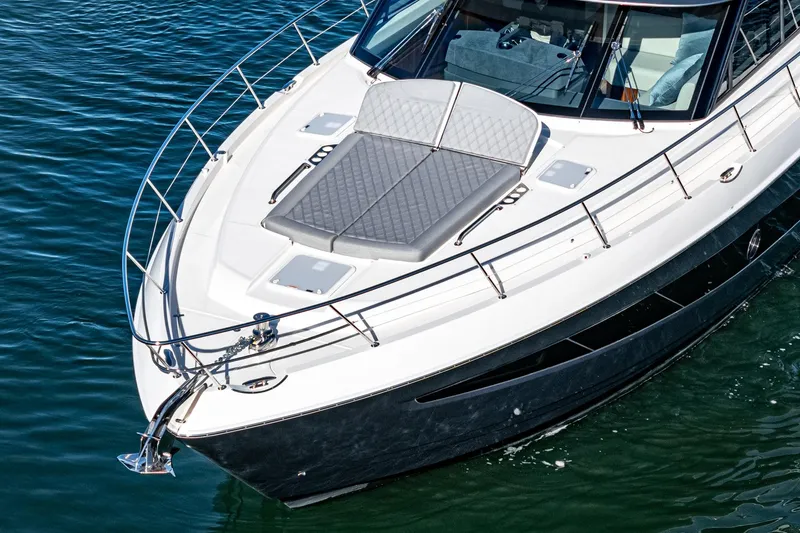 Slide: The Image of 2024 Riviera 5400 Sport Yacht on water, front deck view. - 16