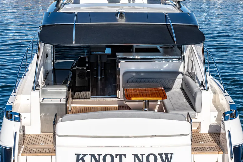 Slide: The Image of 2024 Riviera 5400 Sport Yacht with shaded deck and seating area. - 22