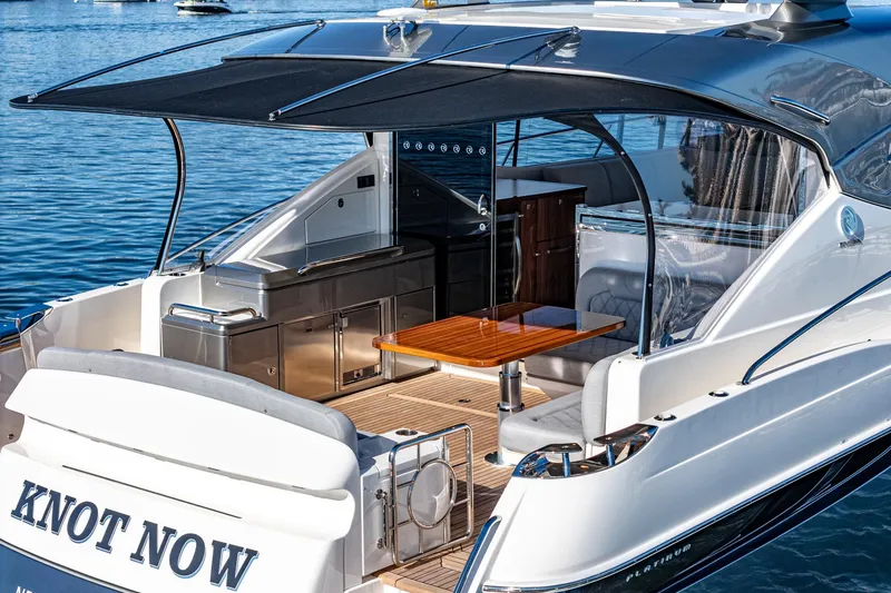 Slide: The Image of 2024 Riviera 5400 Sport Yacht with outdoor seating and kitchen area. - 23