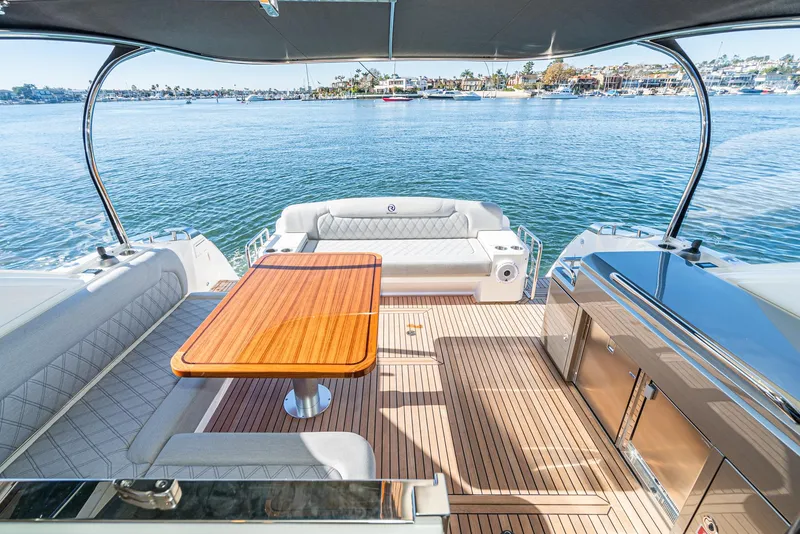 Slide: The Image of 2024 Riviera 5400 Sport Yacht aft deck with seating and ocean view. - 24