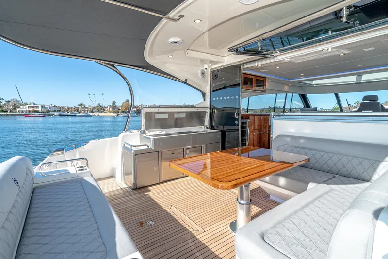 Slide: The Image of 2024 Riviera 5400 Sport Yacht interior with seating and dining area. - 26