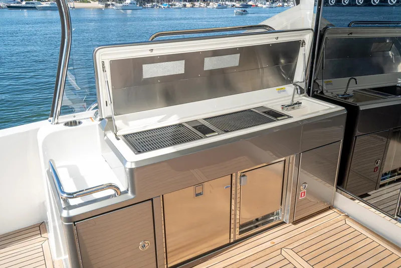 Slide: The Image of Outdoor kitchen on the 2024 Riviera 5400 Sport Yacht with stainless steel appliances. - 27