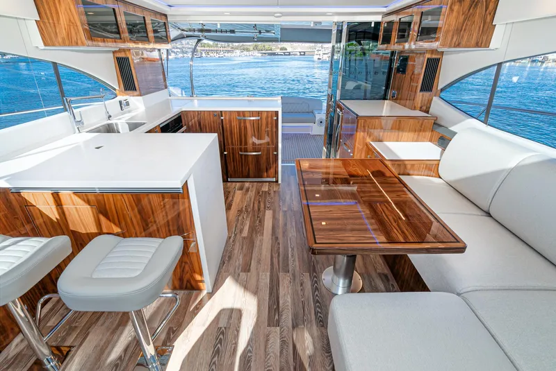 Slide: The Image of 2024 Riviera 5400 Sport Yacht interior with modern kitchen and seating area. - 31