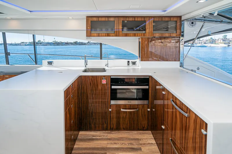 Slide: The Image of Modern kitchen interior of 2024 Riviera 5400 Sport Yacht with wood cabinetry and ocean view. - 35