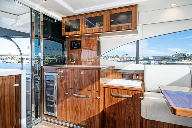 Slide: The Image of Interior of 2024 Riviera 5400 Sport Yacht with wooden cabinetry and waterfront view. - 38