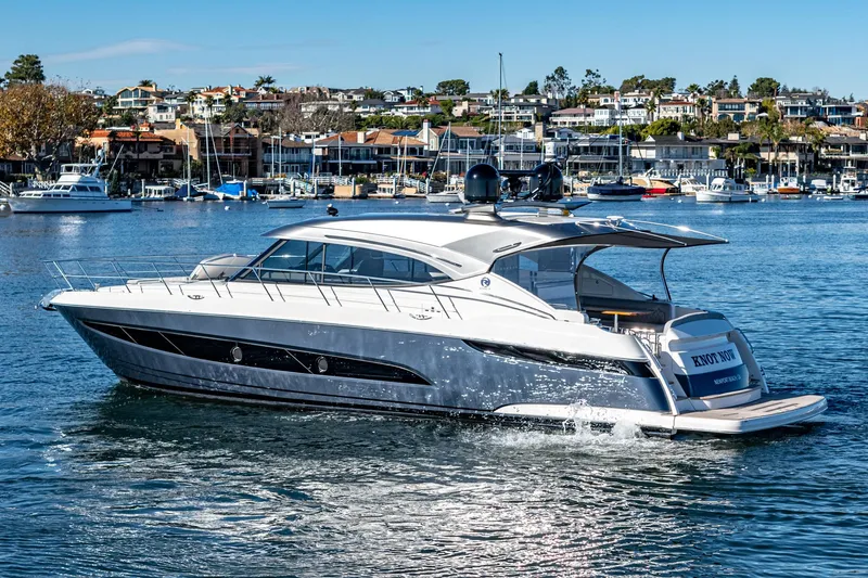 Slide: The Image of 2024 Riviera 5400 Sport Yacht cruising in a scenic marina. - 4
