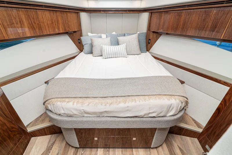 Slide: The Image of Luxurious bedroom interior of 2024 Riviera 5400 Sport Yacht with elegant wood finishes. - 44
