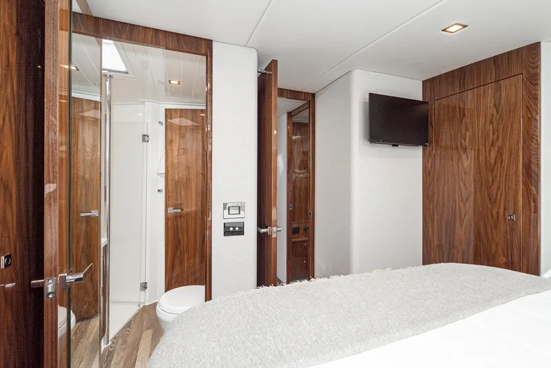 Slide: The Image of 2024 Riviera 5400 Sport Yacht bedroom with ensuite bathroom and wooden finishes. - 45