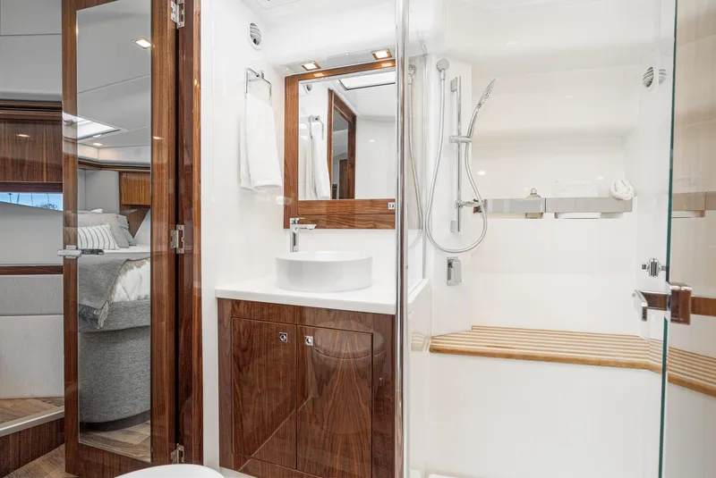 Slide: The Image of Luxurious bathroom in the 2024 Riviera 5400 Sport Yacht with modern fixtures and wooden accents. - 46
