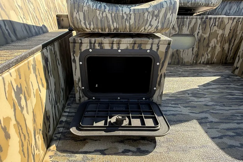Slide: The Image of 2025 Smoker Craft Sportsman 1866 boat interior with camo design and open storage compartment. - 12