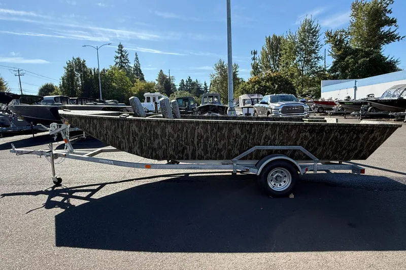 Slide: The Image of 2025 Smoker Craft Sportsman 1866 boat on trailer in parking lot, surrounded by trees. - 3
