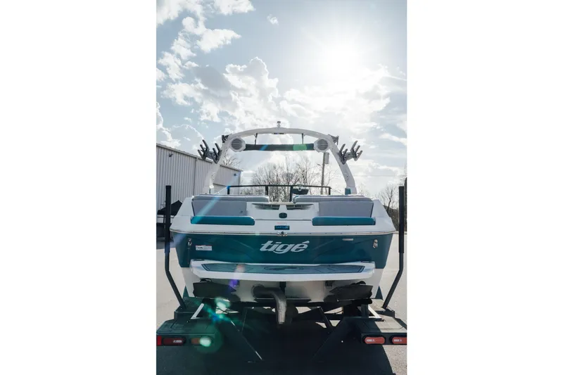 Slide: The Image of 2023 Tigé Z1 boat on trailer under sunny sky. - 2
