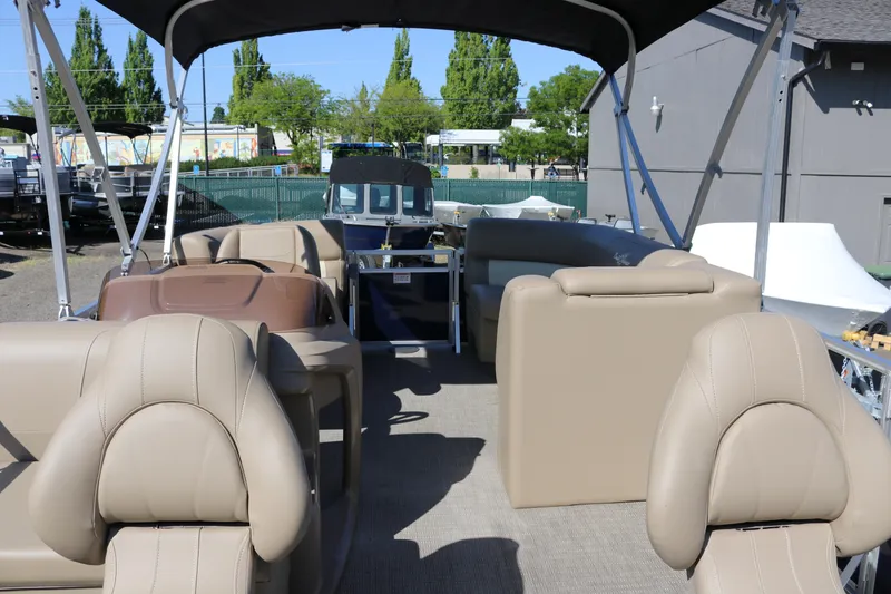 Slide: The Image of 2025 Sun Chaser Vista Fish 18 pontoon boat interior with beige seating and canopy. - 17