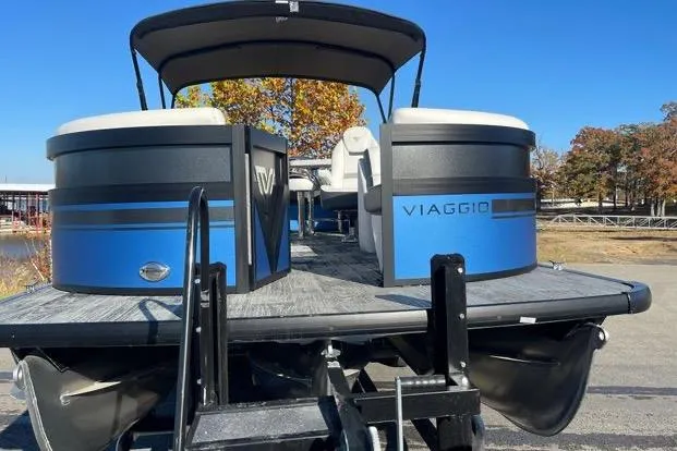 Slide: The Image of 2023 Viaggio Diamante 23B pontoon boat with blue accents, docked outdoors. - 10