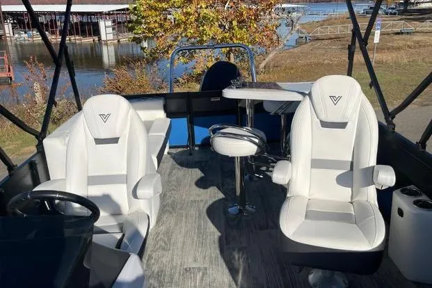 Slide: The Image of 2023 Viaggio Diamante 23B boat interior with white seating and table, dockside view. - 9