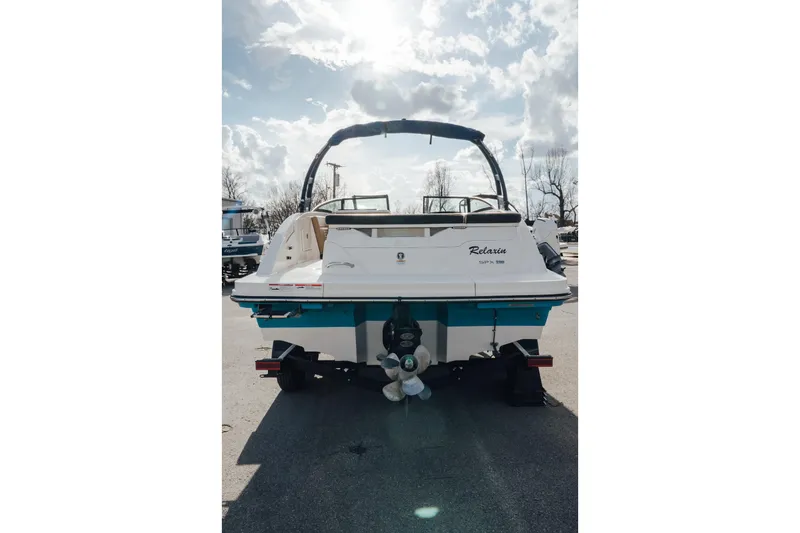 Slide: The Image of 2023 Sea Ray SPX 230 boat, rear view, parked outdoors under a cloudy sky. - 2