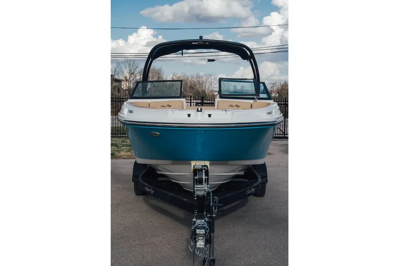 Slide: The Image of 2023 Sea Ray SPX 230 boat on trailer, blue hull, parked outdoors. - 3