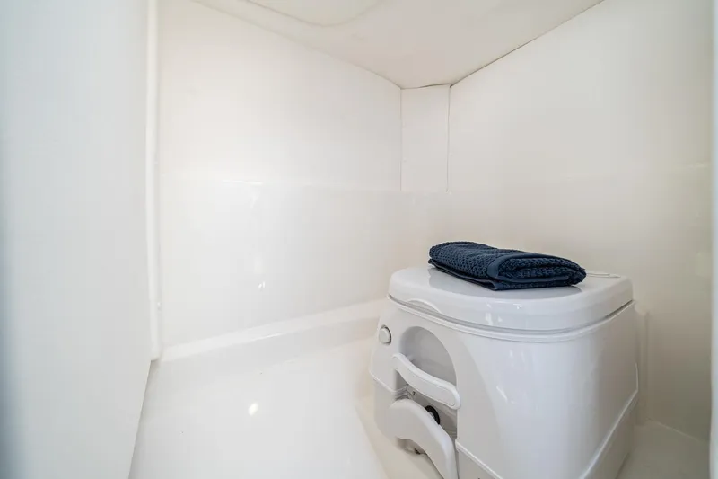 Slide: The Image of Manufacturer Provided Image: Compact bathroom in 2023 Sea Ray SPX 230 OB boat with portable toilet. - 10