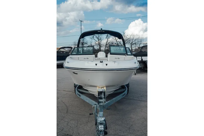 Slide: The Image of 2023 Sea Ray SPX 230 Outboard boat on trailer, front view under cloudy sky. - 2