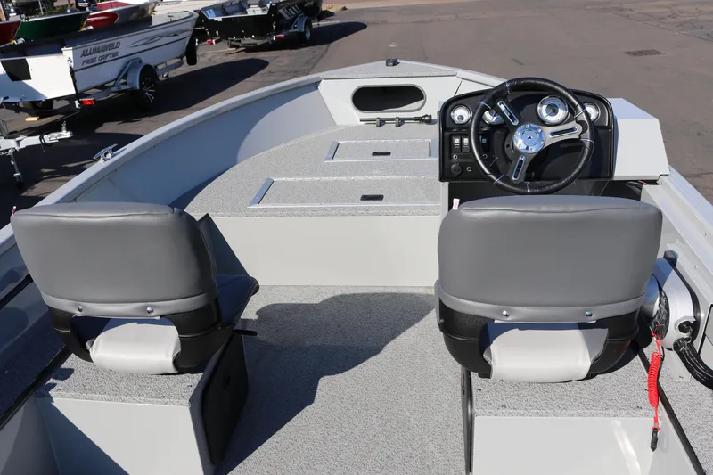 Slide: The Image of 2025 Smoker Craft Pro Lodge 160 boat interior with steering wheel and seating. - 6