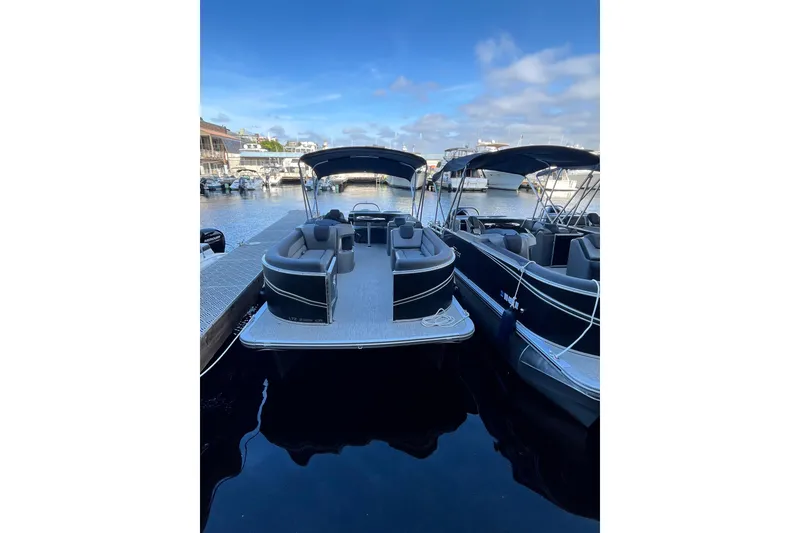 Slide: The Image of 2023 Tahoe Pontoon LTZ Cruise docked at marina under clear blue sky. - 11