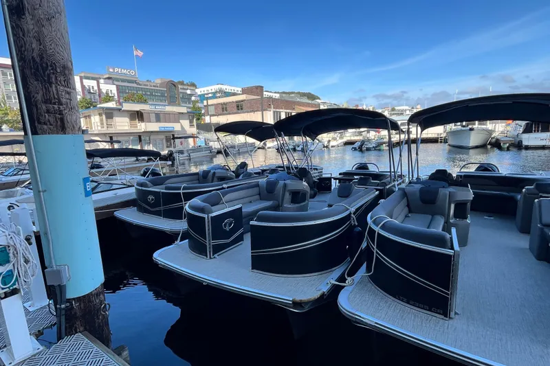 Slide: The Image of 2023 Tahoe Pontoon LTZ Cruise boats docked at a marina under clear blue skies. - 3