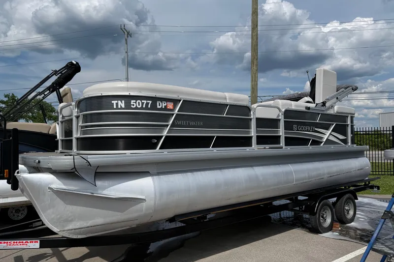 Slide: The Image of 2023 Godfrey Sweetwater 2286 C pontoon boat on trailer under cloudy sky. - 10