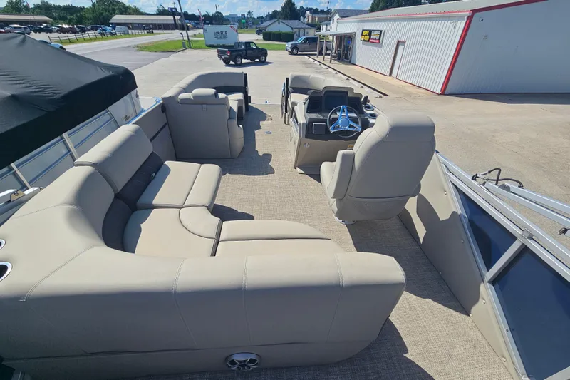 Slide: The Image of 2024 Silver Wave 2410 SW3 RLP pontoon boat interior with beige seating and steering console. - 9