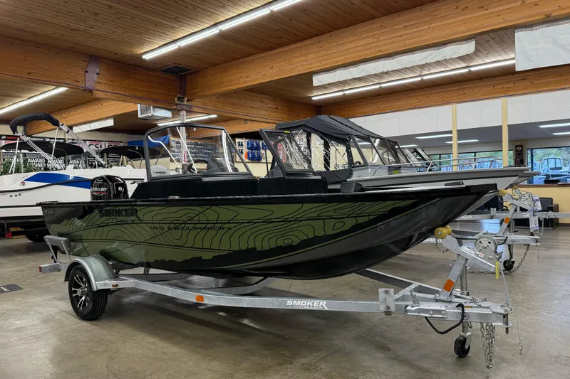The Image of 2025 Smoker Craft Excursion 166 SC Pro boat displayed indoors on a trailer. - 1