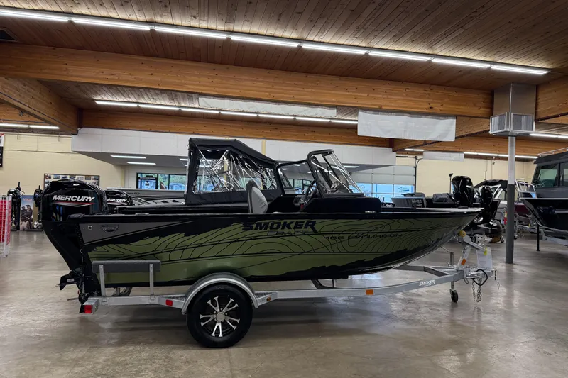 Slide: The Image of 2025 Smoker Craft Excursion 166 SC Pro boat displayed indoors on a trailer. - 9