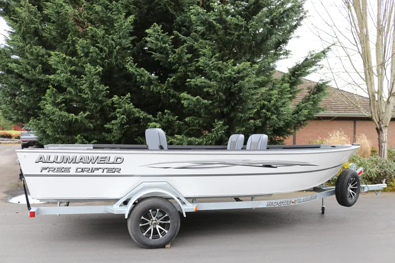 The Image of 2024 Alumaweld Free Drifter 20 boat on trailer, parked outdoors near trees. - 1