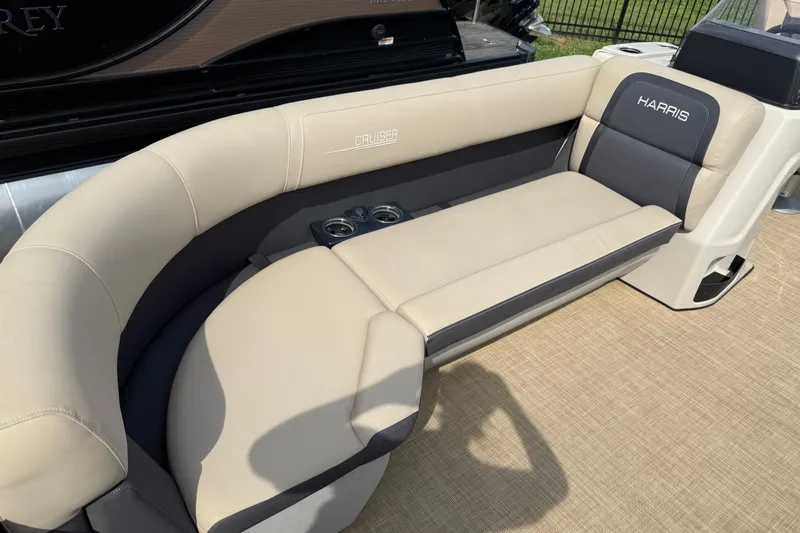 Slide: The Image of 2024 Harris Cruiser 230 boat seating with beige upholstery and integrated cup holders. - 11