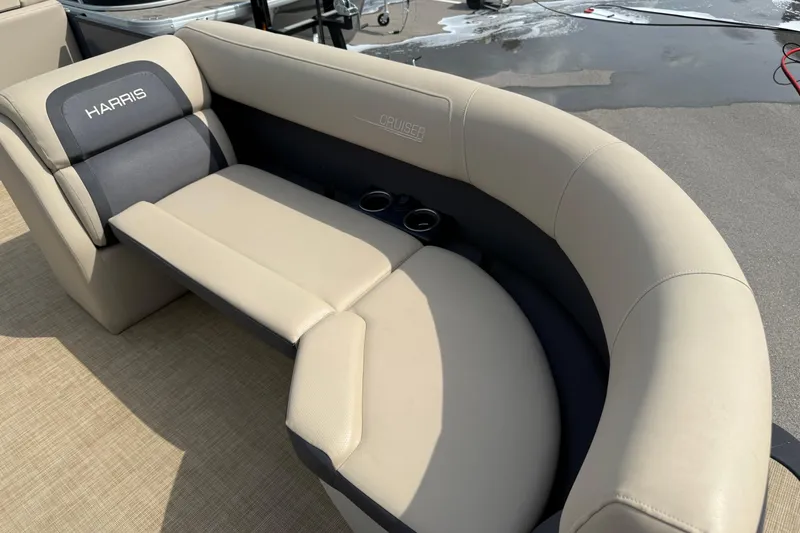 Slide: The Image of 2024 Harris Cruiser 230 boat seating with beige upholstery and cup holders. - 12
