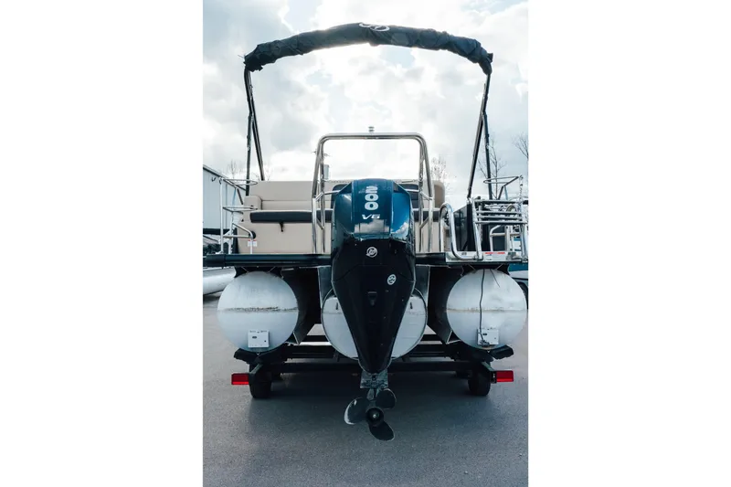 Slide: The Image of 2024 Harris Cruiser 230 pontoon boat with powerful outboard motor, rear view. - 2