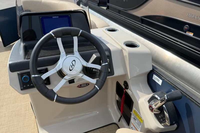 Slide: The Image of 2024 Harris Cruiser 230 boat helm with steering wheel and control panel. - 7